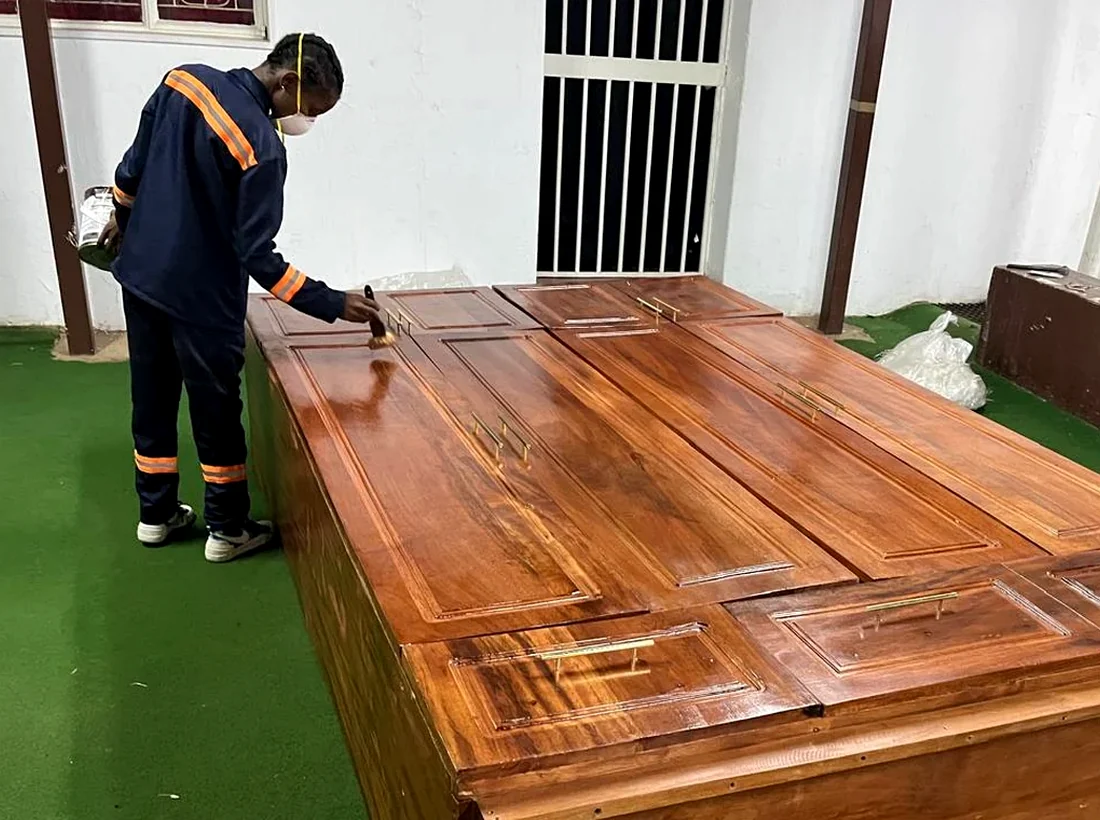 Craftsman applying finish to solid wood furniture